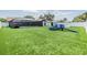Large fenced backyard with well-manicured lawn, playground equipment, and screened pool at 10954 96Th St, Largo, FL 33773