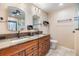 Bathroom with dual sinks, granite countertops, and a ceiling fan at 10954 96Th St, Largo, FL 33773