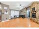 A cozy living room with a vaulted ceiling, stone fireplace, and wood-look laminate flooring at 10954 96Th St, Largo, FL 33773