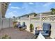 Cozy backyard patio area with brick flooring, white fences, and comfortable blue chairs at 110 Aberdeen Pond Dr, Apollo Beach, FL 33572