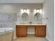 Modern bathroom featuring a dual vanity with ample counter space, stylish lighting, and a luxurious soaking tub at 110 Aberdeen Pond Dr, Apollo Beach, FL 33572