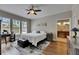 Serene bedroom with large windows, hardwood floors, a comfortable bed, and a convenient workspace and view to bathroom at 110 Aberdeen Pond Dr, Apollo Beach, FL 33572