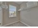 Bright walk-in closet featuring a window, carpet flooring, and shelving for storage at 110 Aberdeen Pond Dr, Apollo Beach, FL 33572