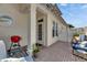 Cozy patio area with brick flooring, white fences, comfortable blue chairs, and a red grill at 110 Aberdeen Pond Dr, Apollo Beach, FL 33572
