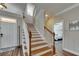 Staircase with wooden rails and white risers, leading to the upper level of the home at 110 Aberdeen Pond Dr, Apollo Beach, FL 33572