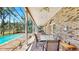 Covered patio with brick floors, fan, and elegant furniture overlooking a pool and backyard at 1141 Myrtle Rd, Valrico, FL 33596