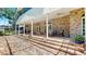 Expansive brick patio with arched windows, ceiling fans, columns and outdoor seating area at 1141 Myrtle Rd, Valrico, FL 33596
