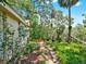 Landscaped backyard with walkway leading to an outdoor wooden deck at 1141 Myrtle Rd, Valrico, FL 33596