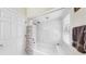 Bright bathroom showcasing shower with tiled walls, a shower curtain and a window with plantation shutters at 1141 Myrtle Rd, Valrico, FL 33596