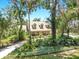 Stunning exterior view of a home with dormer windows, mature trees, and verdant landscaping in a peaceful setting at 1141 Myrtle Rd, Valrico, FL 33596