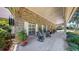 Inviting front porch with chairs, potted plants and windchimes on an attractive brick home at 1141 Myrtle Rd, Valrico, FL 33596