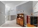 Hallway with carpet flooring, gray walls, and a wooden cabinet featuring decorative ornaments, and adjacent staircase at 1141 Myrtle Rd, Valrico, FL 33596