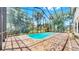 Beautiful backyard showcasing a screened-in pool area with brick pavers and lush landscaping at 1141 Myrtle Rd, Valrico, FL 33596