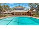 A large screened-in pool with attached home featuring brick columns, multi-pane windows, and patio at 1141 Myrtle Rd, Valrico, FL 33596
