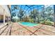 Enclosed pool area with beautiful blue pool, brick flooring, and a screened enclosure allowing sunlight and views at 1141 Myrtle Rd, Valrico, FL 33596