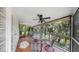 Screened porch with four chairs and a ceiling fan overlooking the backyard at 1141 Myrtle Rd, Valrico, FL 33596