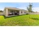 A spacious backyard with lush green grass and a cozy covered patio, ideal for outdoor relaxation at 12401 Shining Willow St, Riverview, FL 33579