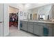 Primary bathroom featuring double vanity with granite counters and a walk-in closet at 12401 Shining Willow St, Riverview, FL 33579