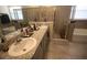 Bathroom featuring a double vanity with granite countertops, a large mirror and a shower with glass doors at 12401 Shining Willow St, Riverview, FL 33579