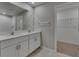 Modern bathroom with double vanity, sleek white cabinets, and a large mirror at 12617 Maple Bonsai Dr, Riverview, FL 33579