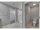 Well-lit bathroom with walk-in shower, toilet, and entrance to a walk-in closet at 12617 Maple Bonsai Dr, Riverview, FL 33579