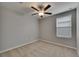 Clean, carpeted bedroom features a ceiling fan and natural light from a window at 12617 Maple Bonsai Dr, Riverview, FL 33579