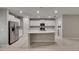 Open concept kitchen with stainless steel appliances, white cabinets, and a large center island at 12617 Maple Bonsai Dr, Riverview, FL 33579