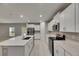 Spacious kitchen with stainless steel appliances, a large island with a sink, and ample cabinet space at 12617 Maple Bonsai Dr, Riverview, FL 33579