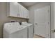 Laundry room featuring a washer, dryer, and overhead cabinets for storage at 12617 Maple Bonsai Dr, Riverview, FL 33579
