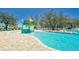 Community pool and splash pad with a lounge area and ample seating under blue skies at 12617 Maple Bonsai Dr, Riverview, FL 33579