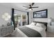 This bedroom offers a calm atmosphere, complete with neutral-toned furniture and natural light streaming through a large window at 12804 Bert Pl, Tampa, FL 33625