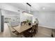 Open-concept dining area with a large wooden table and elegant lighting, connects to the kitchen at 12804 Bert Pl, Tampa, FL 33625