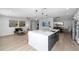 A modern kitchen boasts a central island with white marble countertops, seamlessly connecting to a living and dining area at 12804 Bert Pl, Tampa, FL 33625