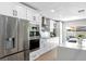 Modern kitchen with stainless steel appliances, white cabinets, and a stylish range hood with direct access to the patio at 12804 Bert Pl, Tampa, FL 33625