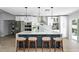 Modern kitchen boasts white cabinetry, stainless steel appliances, and a central island with bar seating at 12804 Bert Pl, Tampa, FL 33625