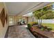 Inviting outdoor patio featuring a brick-paved walkway and lush tropical landscaping at 12804 Bert Pl, Tampa, FL 33625