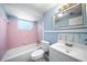 Bathroom with pink tile and a new white toilet, sink, and tub at 12901 College Hill Dr, Hudson, FL 34667