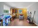 Bonus room with wood floors, two windows, desk, chair, and assorted exercise equipment at 12901 College Hill Dr, Hudson, FL 34667
