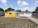 Charming single-story home featuring a yellow accent wall, a white door, and an attached garage at 12901 College Hill Dr, Hudson, FL 34667
