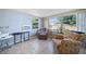 Cozy living room with tile floors, with two chairs and natural light from the two large windows at 12901 College Hill Dr, Hudson, FL 34667
