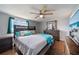 Spacious primary bedroom features hardwood floors, ceiling fan and dresser with mirror at 12901 College Hill Dr, Hudson, FL 34667