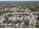 An aerial view of a neighborhood with tree lined streets, many houses, and nearby woods at 12901 College Hill Dr, Hudson, FL 34667