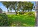 Lush green backyard with mature trees and a white fence, offering a serene and private outdoor space at 13028 Prestwick Dr, Riverview, FL 33579