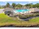 Stunning pool area features a pool, cabana, and lush landscaping with a view of a serene pond at 13028 Prestwick Dr, Riverview, FL 33579