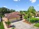Well-maintained home exterior featuring a three-car garage, mature landscaping, and a neatly manicured lawn at 13028 Prestwick Dr, Riverview, FL 33579