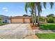 Spacious single-story home featuring a three-car garage, mature trees, and well-maintained landscaping at 13028 Prestwick Dr, Riverview, FL 33579