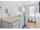 Bright laundry room with washer, dryer, cabinets, sink, and large window at 13028 Prestwick Dr, Riverview, FL 33579