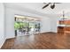 Open concept living room with wood flooring and access to a screened in patio with outdoor dining set at 13028 Prestwick Dr, Riverview, FL 33579