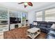 Comfortable living room featuring a ceiling fan, wood flooring, and a large black leather sectional sofa at 13028 Prestwick Dr, Riverview, FL 33579