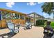 Outdoor patio area featuring Adirondack chairs, a grill, and a screened-in lanai for relaxing and entertaining at 13028 Prestwick Dr, Riverview, FL 33579